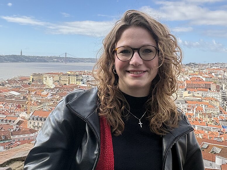 Junge Frau vor der Kulisse einer Stadt 