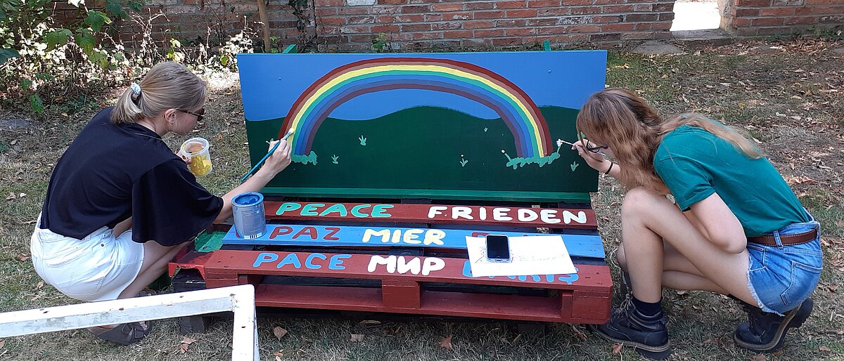 Zwei Freiwillige beim Bemalen eines Schildes